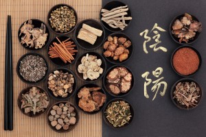 Chinese herbal medicine with yin and yang calligraphy script over bamboo. Translation reads as yin yang.